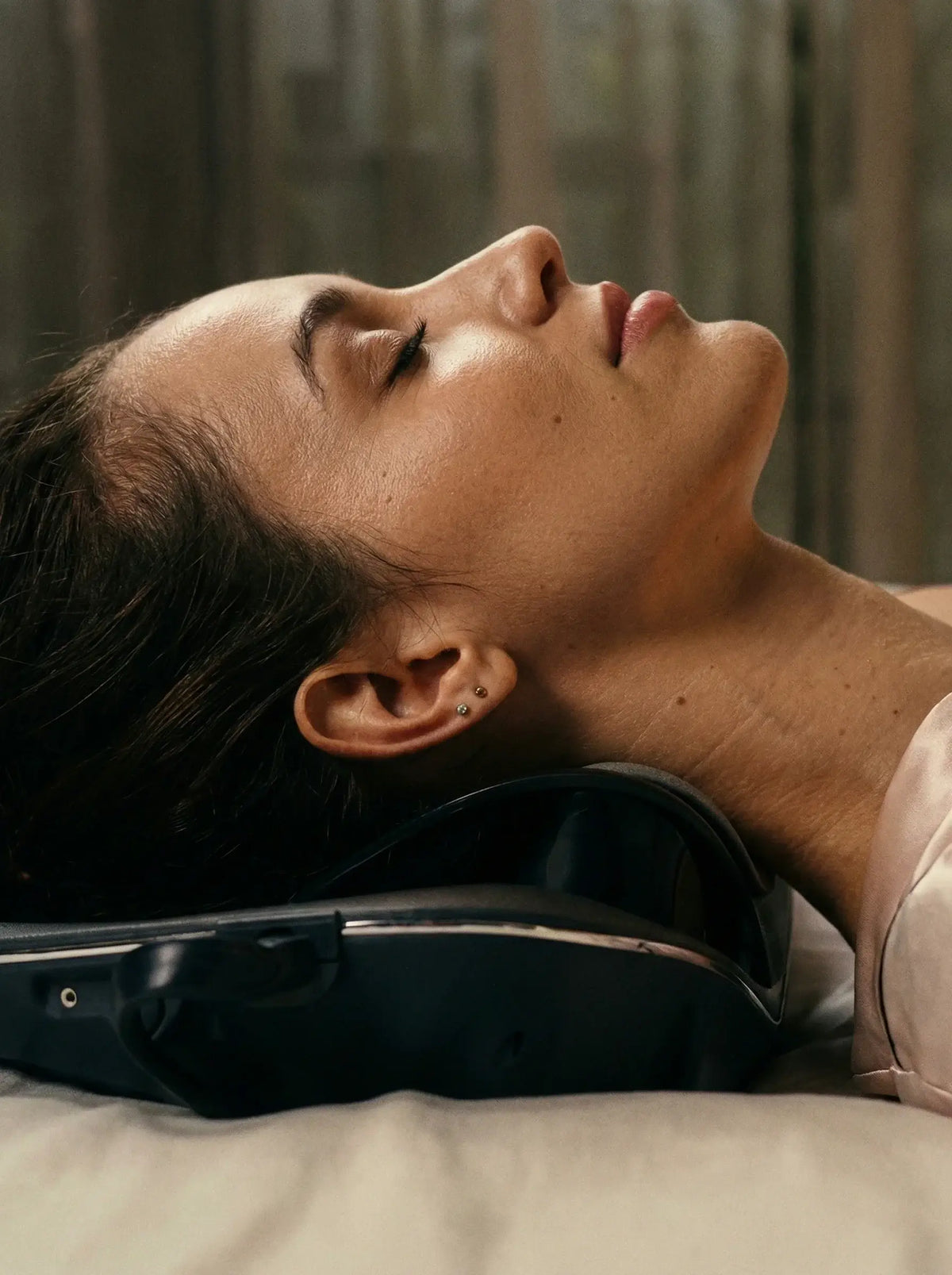 Model using a neck massager for relaxation, focusing on Neck Care Essentials.