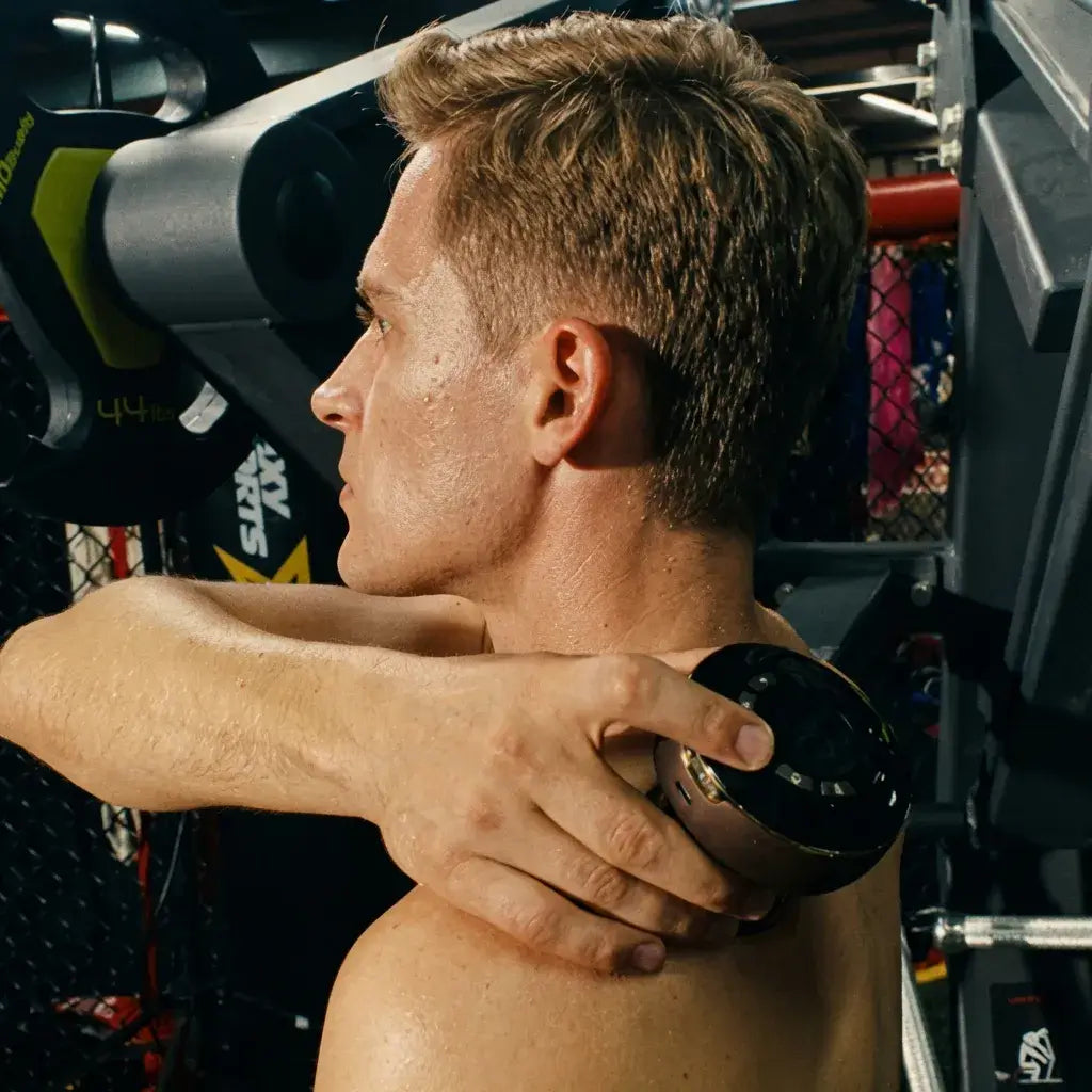 Man using AcheFly Smart Cupping Device on his shoulder for muscle relief during workout.