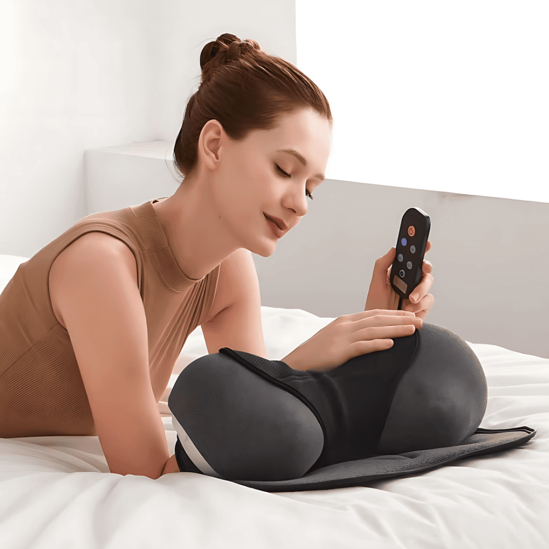 Woman relaxing with the CerviCloud Neck Stretch Pillow while using a remote control in a cozy setting.