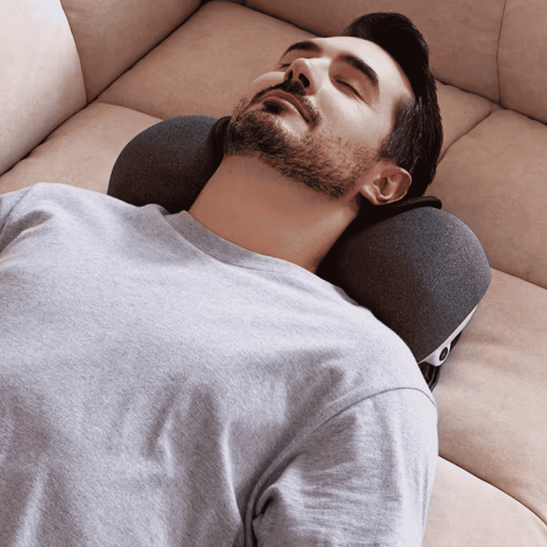 Man relaxing with CerviCloud Neck Stretch Pillow on a sofa, enjoying comfort and support.