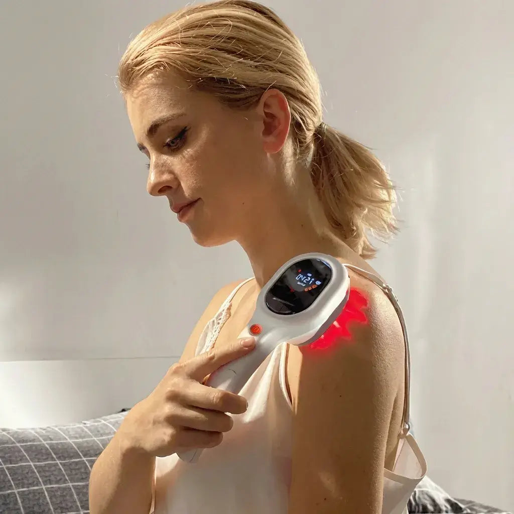 Woman using Dernox Cold Laser Wand on her shoulder to apply targeted light therapy.
