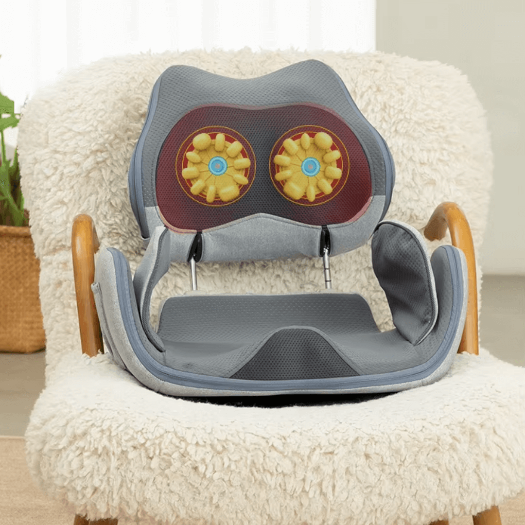 Hipology Massage Seat positioned on a cozy chair, showcasing its therapeutic design with kneading rollers.