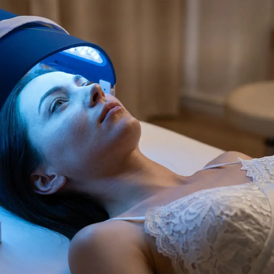 A woman lying down under a LumiCura Flexible Light Panel for relaxation and light therapy.
