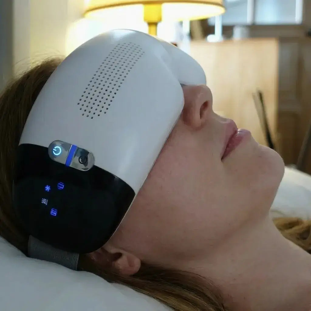 A woman relaxes while using the Visura 3D Eye Massager, designed for eye comfort and relaxation.
