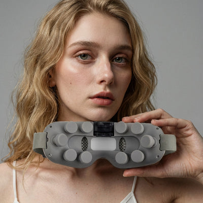 Auri 3D Steam Eye Massager held by a model, showcasing the device's design and control panel.