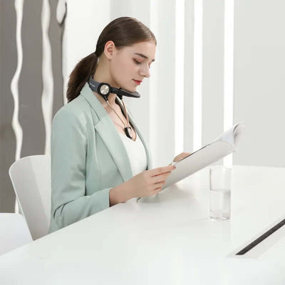 Woman using Cerviocare Neck Support Wear while reading a magazine at a modern desk.