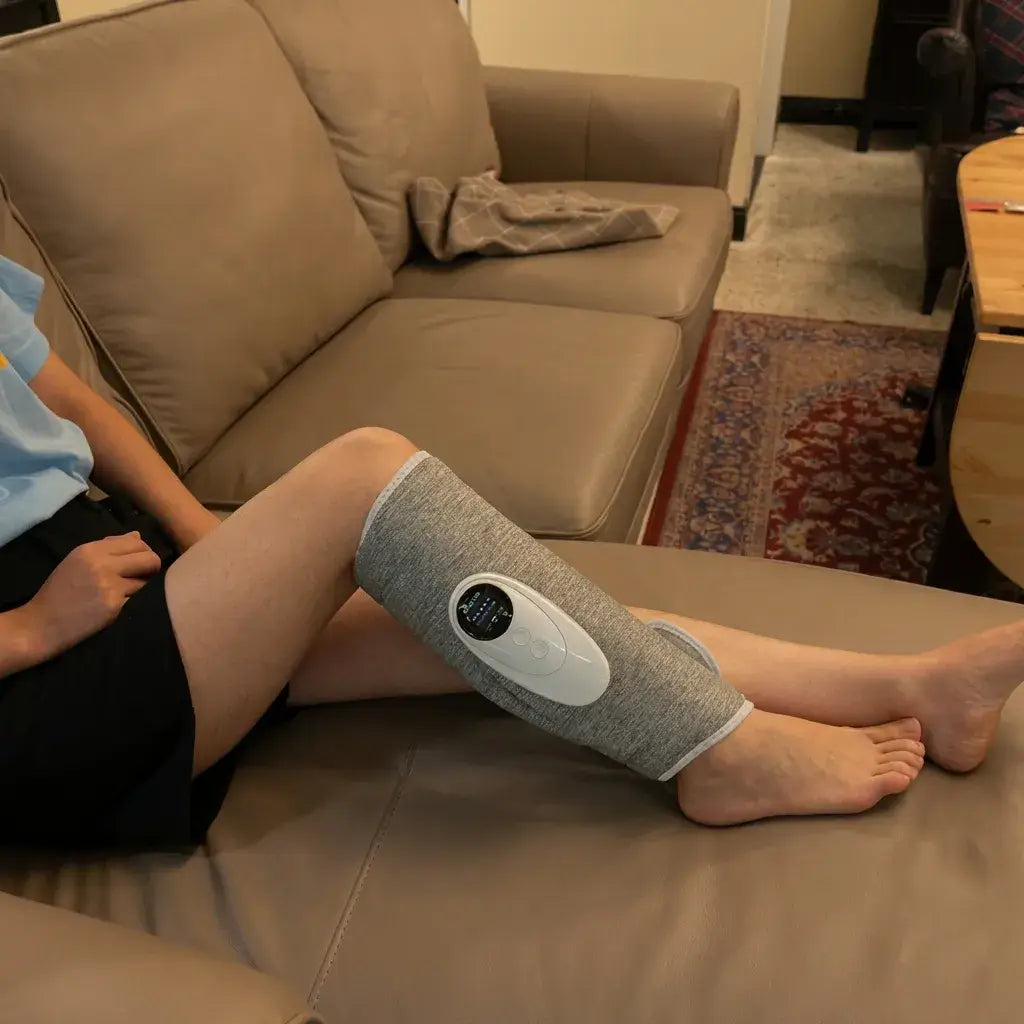 Person using the Halipax Calf Massager while sitting on a couch at home, relaxing their calf.