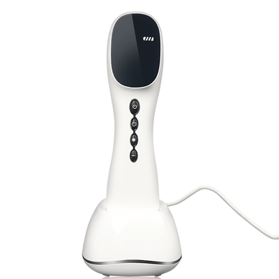 Dernox Pro Cold Laser + TENS device in a white finish with control buttons and a charging base.