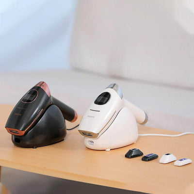 AP10 IPL Hair Removal Device in black and white with interchangeable heads on a wooden table.