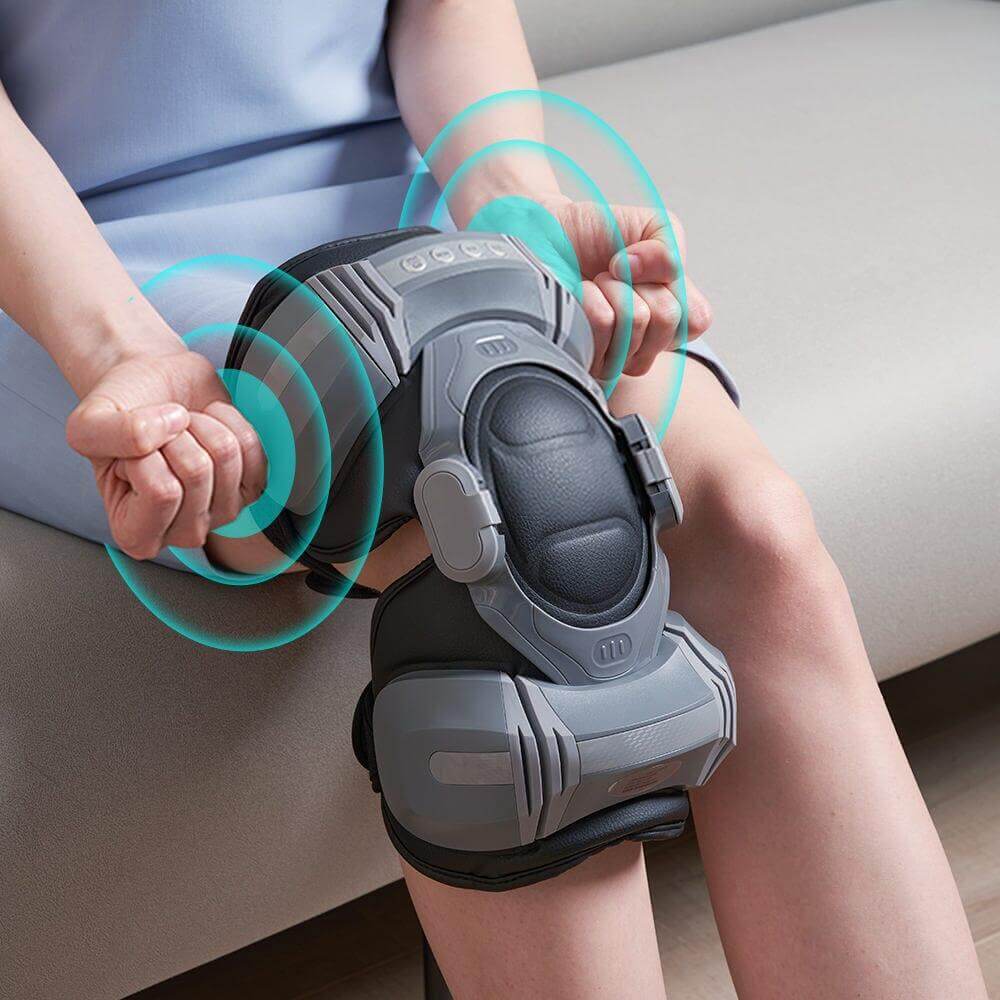 User applying the FlexWave Air Knee Massager on their knee while seated, showcasing its ergonomic design.